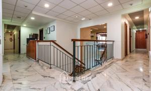 a lobby with marble flooring and a staircase at Hotel Playa Poniente in Gijón