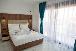 a bedroom with a large bed with blue curtains at Hotel Lejla in Ulcinj +63 photos