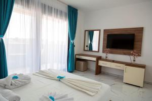 a bedroom with a bed and a desk and a television at Hotel Lejla in Ulcinj