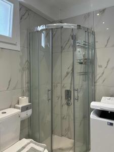 a bathroom with a shower with a glass door at Anesis in Néa Péramos +15 photos