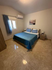 a bedroom with a bed with blue sheets and a window at F&R Villa - Family Apartment No6 - 2 bedrooms in Perea