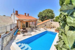a swimming pool in front of a house at Villa Milla by aneo travel in Novi Vinodolski