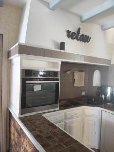 una cocina con estufa y microondas en Charming house, en Aytré