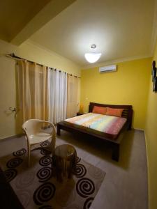 a bedroom with a bed and a chair in it at Villa Sahitia Marine in Mahajanga