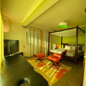 a bedroom with a canopy bed and a chair at Villa Sahitia Marine in Mahajanga