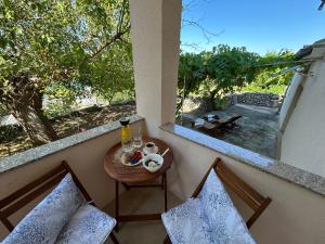 ein Balkon mit Tisch und Stühlen und einem Fenster in der Unterkunft Apartmani Luka & Iva in Šibenik