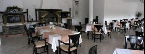 a dining room with tables and chairs and a fireplace at Park Hotel Panorama in Tryavna