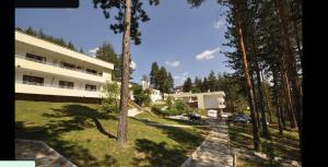 a view of a building with a yard and trees at Park Hotel Panorama in Tryavna