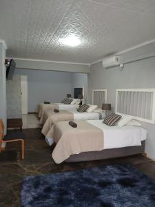 una stanza con un sacco di letti di Victoria Oaks Beaufort West Guesthouse a Beaufort West