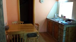 a kitchen with a wooden table and a sink at Holiday Home Baracka in Bezdan