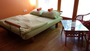 a bedroom with a bed and a table and a window at Holiday Home Baracka in Bezdan