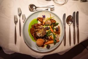 un piatto di cibo su un tavolo con argenteria di Hotel Starkenberg a Scena