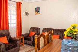 a living room with two couches and a table at Hilda's gem in Embu
