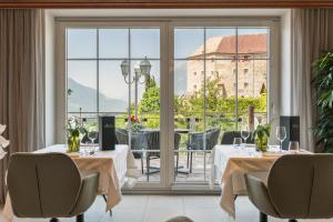 un ristorante con due tavoli e una grande finestra di Hotel Starkenberg a Scena