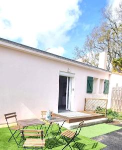 a white house with a picnic table and chairs at Appartement proche de l'aéroport de Nantes in Saint-Aignan-Grand-Lieu