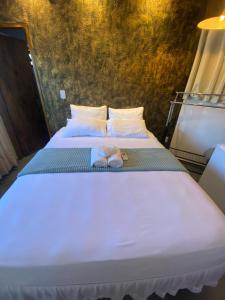 a bed with two slippers sitting on top of it at Amoras suítes in Sao Jorge