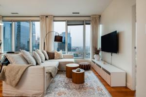 a living room with a white couch and large windows at Chic Downtown Apartment with City Views near Stanley Park in Vancouver