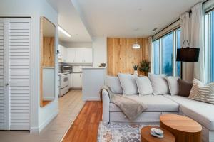a living room with a couch and a kitchen at Chic Downtown Apartment with City Views near Stanley Park in Vancouver