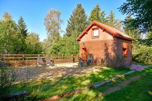 un granero con una mesa y sillas en un patio en Le Refuge, en Gérardmer