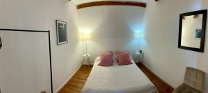 een kleine kamer met een bed met 2 roze kussens bij KVS Concept Hébergement haut de gamme près du Circuit des 24 Heures du in Écommoy