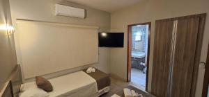 a hotel room with a bed and a television at Rede Andrade Center Premium in Rondonópolis +48 photos