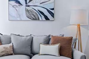 a couch in a living room with a painting on the wall at Elevate Brisbane City - Views, Pool, Sauna & Gym in Brisbane +26 photos