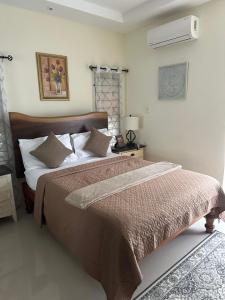 a bedroom with a large bed with a brown comforter at Villa Christine in Ocho Rios +25 photos