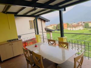 a table and chairs on a balcony with a view at La terrazza del nonno in Dongo +21 photos