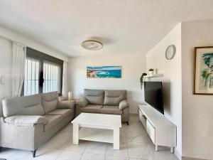 a living room with a couch and a tv at Appartement AMALIA in Orihuela Costa