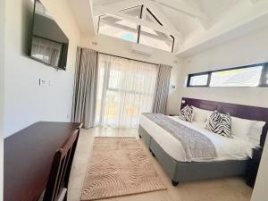 a bedroom with a bed and a large window at 19 On Bay Noakes in Harare +19 photos