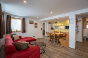 a living room with a red couch and a dining room at Chalet Morgenrot in Arni Alp