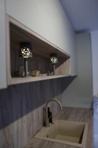 a kitchen with a sink and two lights on a shelf at Villa L&M in Bihać