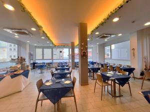 a dining room with blue tables and chairs at Hotel Atlas in Gabicce Mare