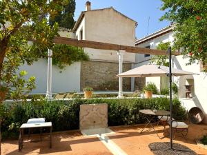 グラナダにあるCarmen de Ramilla, encantadora Guesthouse con piscina soleadaの建物前のテーブルと傘