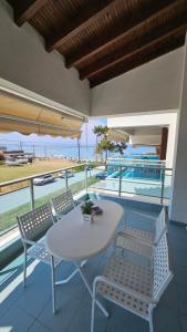 a table and chairs on a balcony with a view of the ocean at Bungalow White Apartments in Polychrono