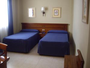 pokój hotelowy z dwoma łóżkami i stołem w obiekcie Hotel Manolo Mayo w mieście Los Palacios y Villafranca