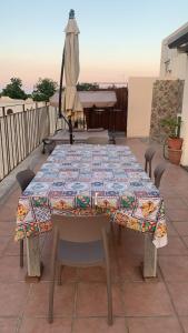 a table with a quilt on a patio with an umbrella at Home Giove in Giardini Naxos +19 photos