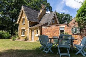 a house with a table and chairs in the yard at Gate Lodge - Sleeps 4 - Near Belvoir Castle in Knipton
