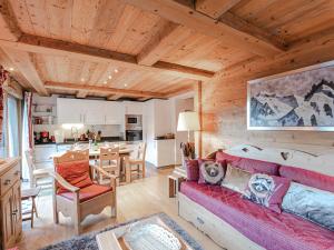salon z czerwoną kanapą i kuchnią w obiekcie Charmant appartement près pistes et centre, WiFi, parking privatif - FR-1-343-193 w Chamonix-Mont-Blanc