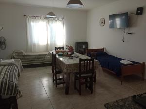 ein Wohnzimmer mit Tisch und Bett in der Unterkunft Alquiler Temporario CF in San Carlos de Bolívar