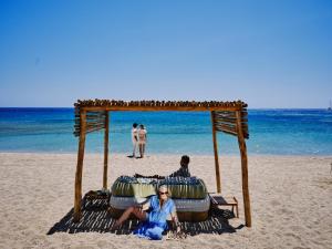 アグラリにあるMyconian Sunrise Relais & Chateaux Hotelのビーチに座っている人々のグループ