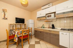 a kitchen with a table and a white refrigerator at tiho's apartments in Split