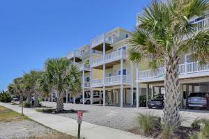 a large apartment building with palm trees in front of it at 5 Bedroom home located in Heart of Surf City, beach access across street in Surf City