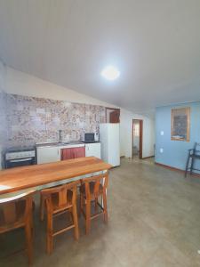 une pièce avec une table et des chaises et une cuisine dans l'établissement Casa em Canasvieiras - Beira mar, à Florianópolis