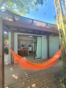 un hamac orange sur une terrasse avec une maison dans l'établissement Casa em Canasvieiras - Beira mar, à Florianópolis
