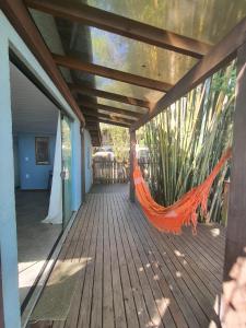 un hamac orange sur le porche d'une maison dans l'établissement Casa em Canasvieiras - Beira mar, à Florianópolis