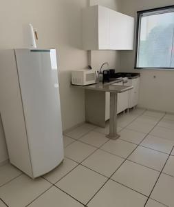 eine Küche mit einem Kühlschrank und einem Tisch darin in der Unterkunft Apto funcional e bem equipado in Maringá