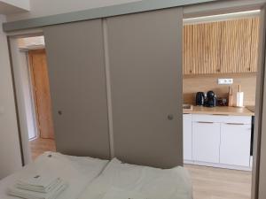 a bedroom with a white bed and a kitchen at Apartament 512 in Dziwnówek +14 photos