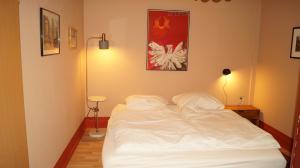 a white bed in a room with a lamp at Ferienwohnung Ida Pfeiffer in Eibenstock