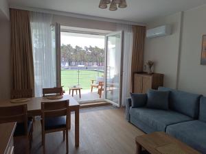 a living room with a blue couch and a table at Apartament 512 in Dziwnówek